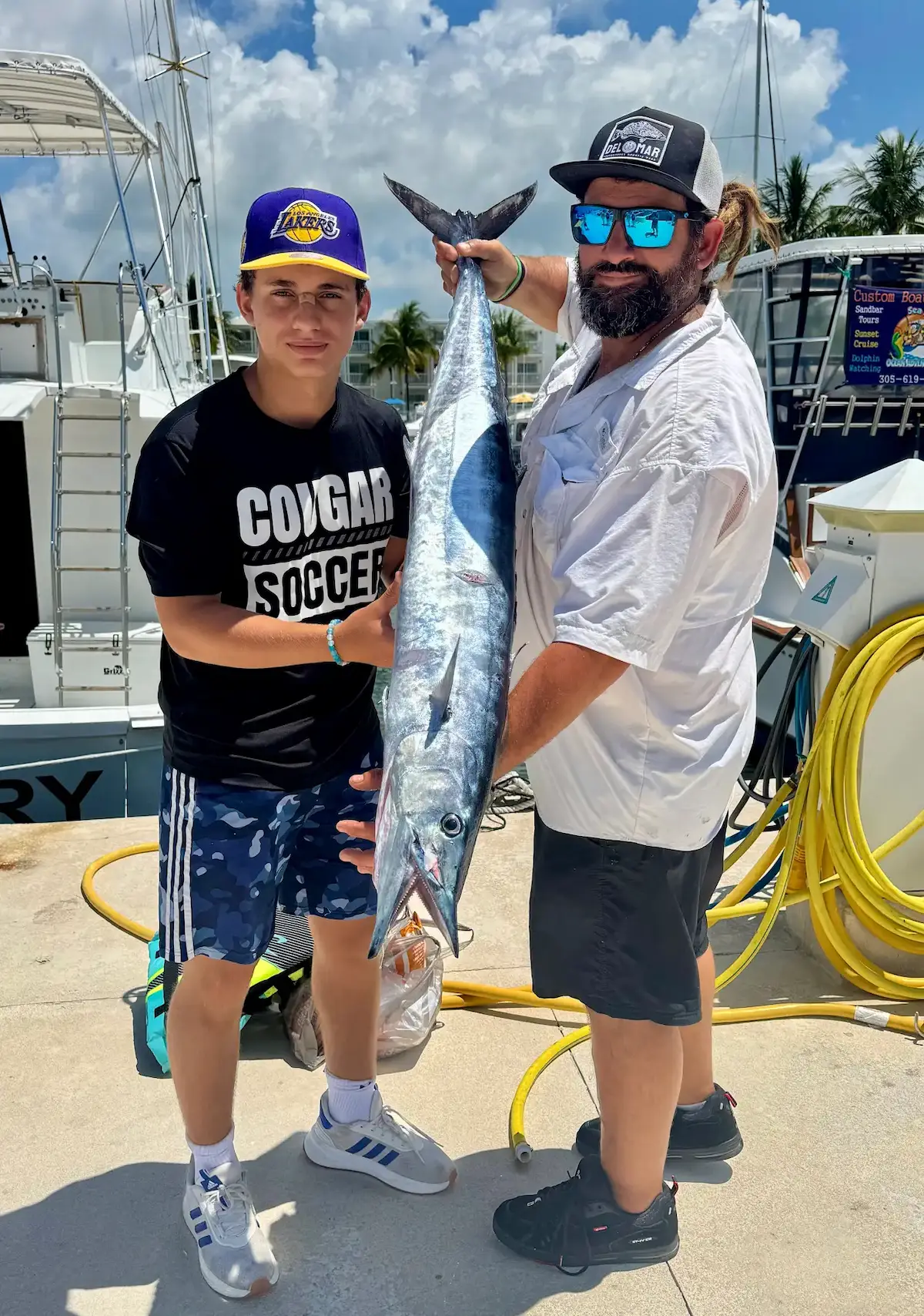 Father and son with impressive kingfish catch at the dock